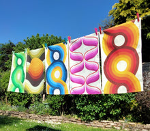 Load image into Gallery viewer, Washing line of retro 70s tea towels in pink, orange, blue green and yellow